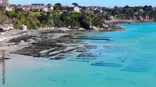 Aerial drone view of oyster farm structures on the coast near Cancale, France, highlighting shellfish aquaculture and seafood production