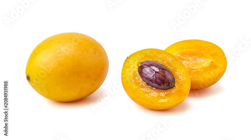 Fresh marian plum fruits whole and halved isolated on white background