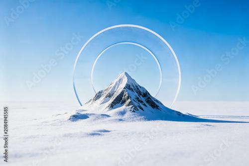 A snow-capped mountain stands in a vast icy plain, framed by two large transparent circular shapes against a clear blue sky.