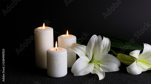 Burning Candles and White Lily Flowers on Black Background with Copy Space, Funeral and Condolence Concept