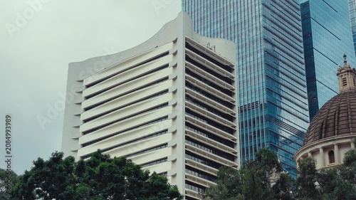 A dynamic urban scene in Hong Kong featuring modern high-rise architecture blending with historic elements.