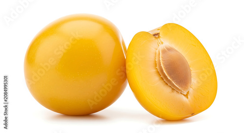 Whole and halved yellow plum with stone fruit