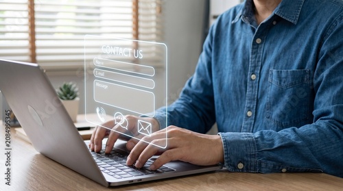 Canvastavla Business professional typing on laptop with virtual contact us form interface fo