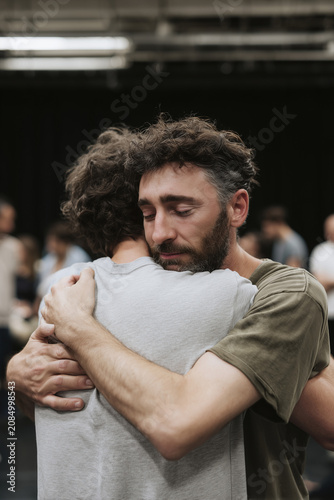 Two Men Embracing and Hugging Comforting Each Other with Emotional Expression