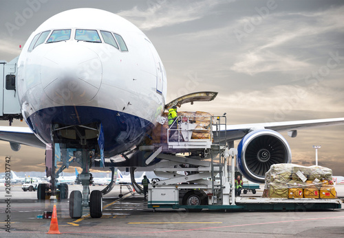 Foto loading cargo into the airplane before departure with nice sky