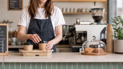 Coffee shop owner preparing takeaway drinks in a modern café