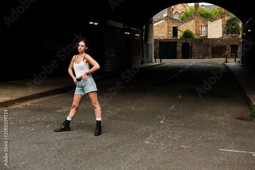 Foto Young woman posing confidently in urban archway underpass