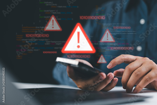 Cybersecurity threat warning on smartphone with red alert icon signaling hacking attempt, virus infiltration, and data breach while user checks phone at home, showing mobile cyberattack risk