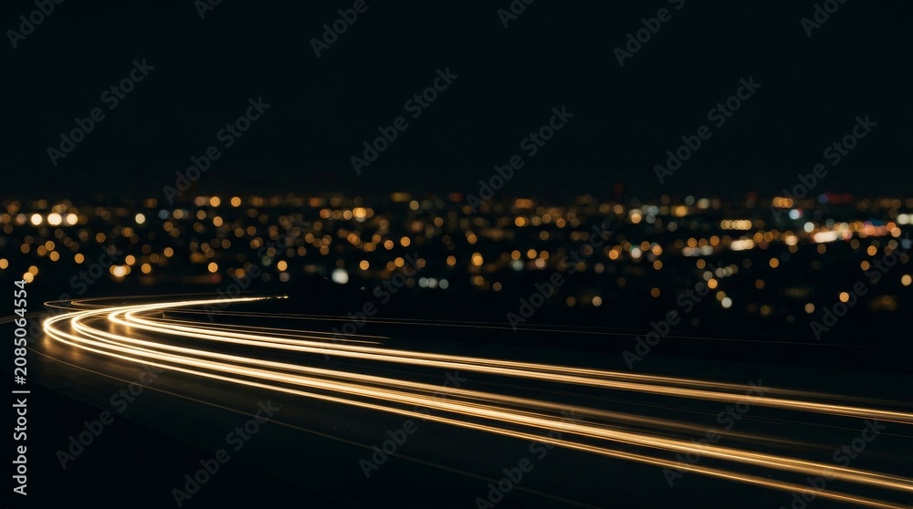 Fototapeta premium Light trails from traffic on a highway at night near a city.