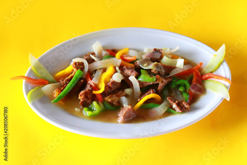Spicy Beef Stir Fry with Colorful Bell Peppers on Vibrant Yellow Background