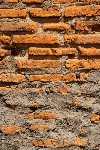 Fotografie Red brick wall with a rough, textured surface