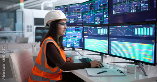 Foto Young Woman Engineer Uses Computer