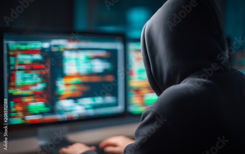 Cyber Attacker in Holographic Environment with Dark Silhouette at Computer