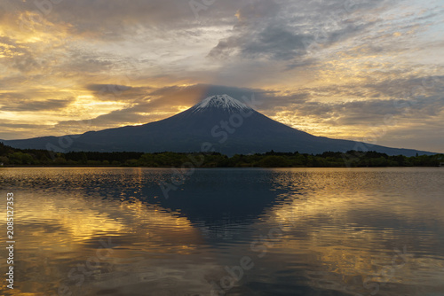 Majestic golden sunrise illuminating Mount Fuji and the rippling water of Lake Tanuki in spring, Fujinomiya, Shizuoka, Japan.