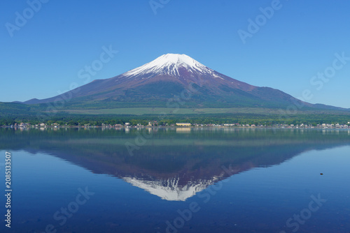 Принти на полотні Perfect symmetrical reflection of the snow-capped Mount Fuji on the crystal-clear water of Lake Yamanakako in May, Yamanashi, Japan