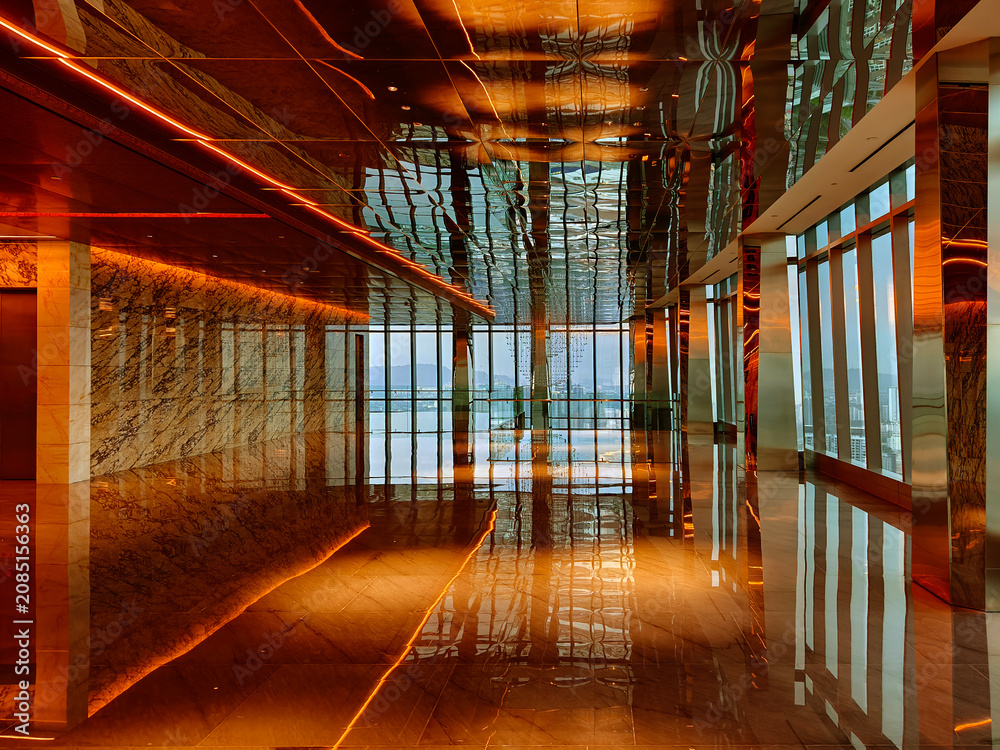 Obraz premium Spacious glass atrium with reflections on polished floor and panoramic windows. Empty lobby features