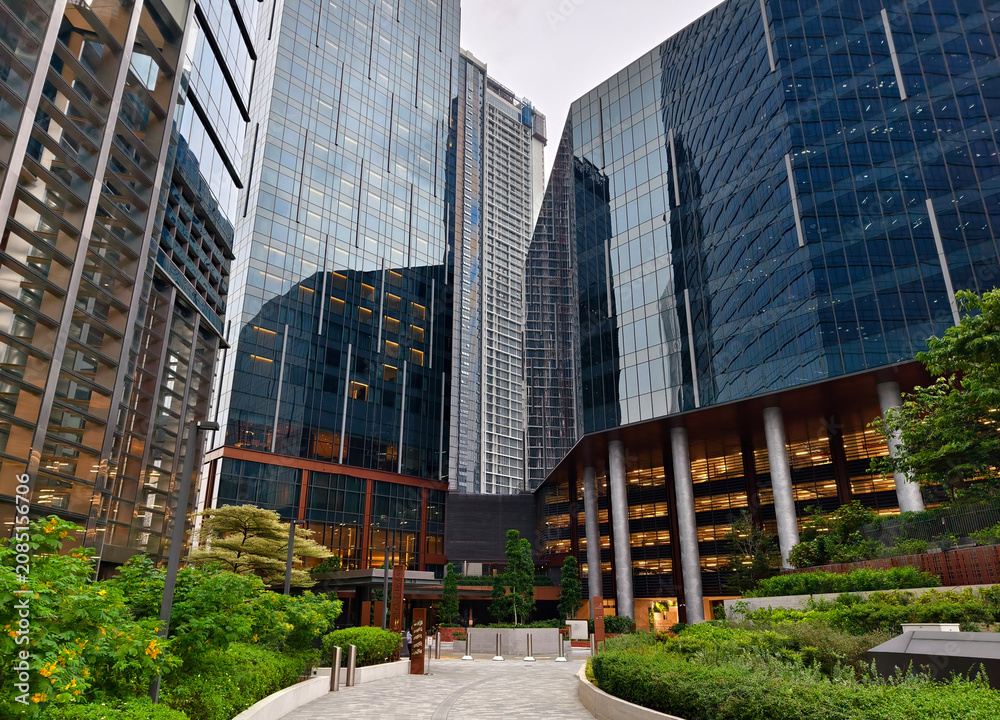 Obraz premium Ground level plaza with columned entrance, inviting steps and greenery frame office lobby.