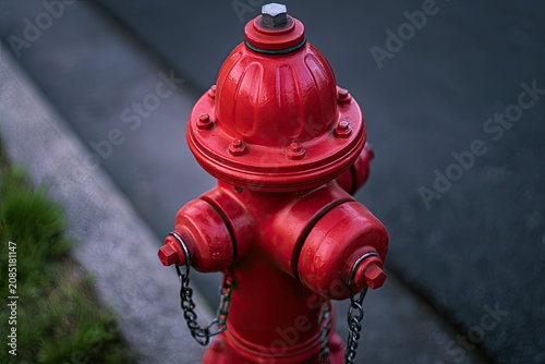 Vibrant red fire hydrant stands guard on a street's edge, ready for action