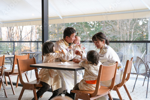 Fotografie Family shares joyful moments in a sunlit cafe