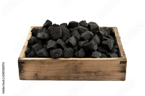 Wooden box filled with black charcoal chunks for grilling or heating purposes