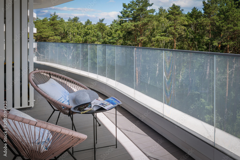 Obraz premium Modern balcony with forest view and terrace furniture