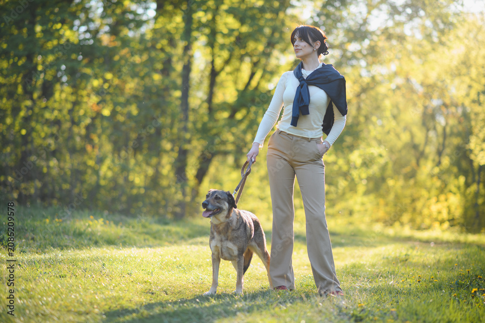 Fototapeta premium Woman walking dog in nature park during summer
