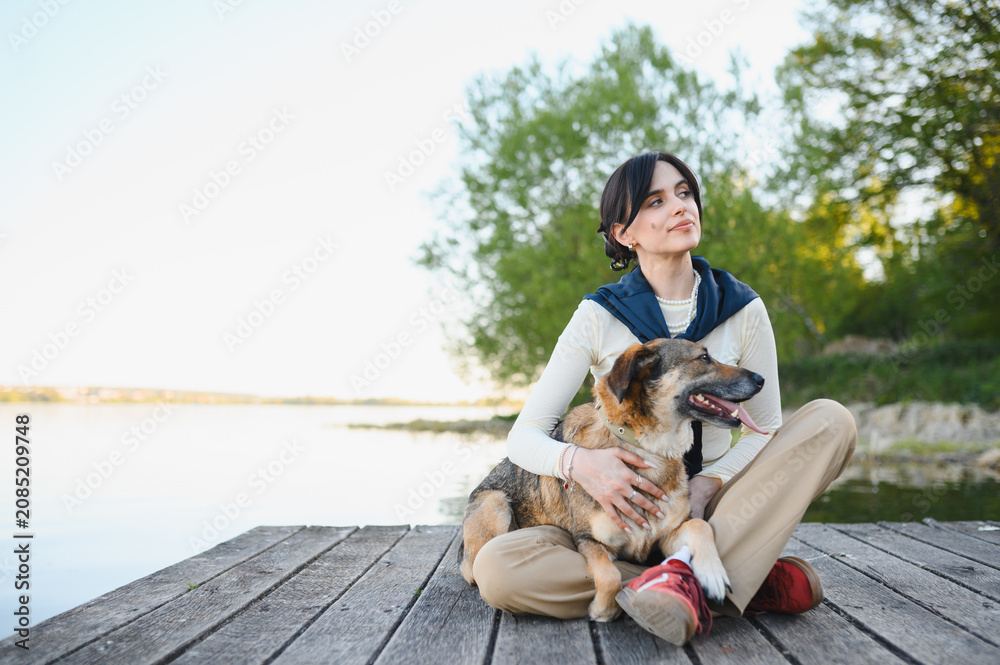 Fototapeta premium Woman and dog enjoying peaceful moment by lake