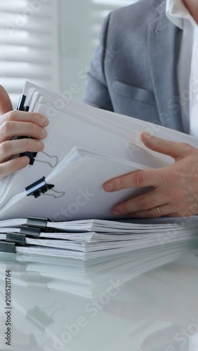 Photos Business professional hands actively managing a large stack of office documents