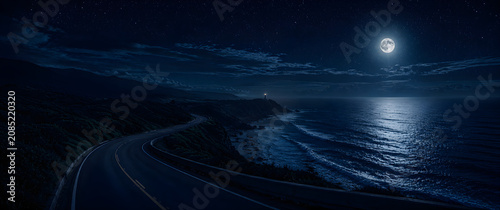 Winding coastal highway at night illuminated by a bright full moon with a distant lighthouse