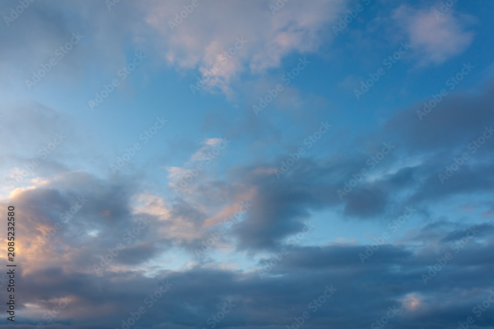 Obraz premium Dramatic sunset sky with layered clouds in blue and golden hues