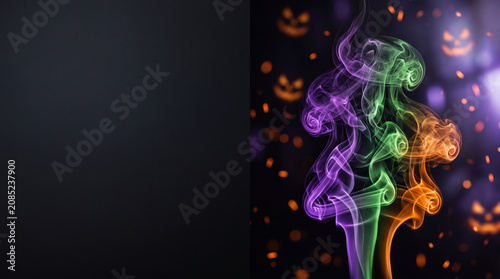 Abstract Halloween background with swirling colorful smoke and glowing pumpkin faces