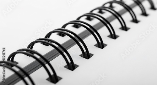 Close-up view of a spiral notebook binding showcasing the metal rings and paper.