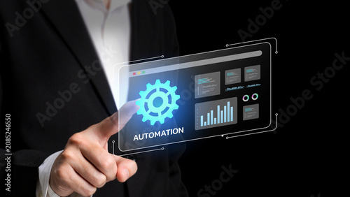 Automated Business Interface: A businessman in a suit touches a digital screen displaying an interface with gears and charts, symbolizing automation and data analysis.