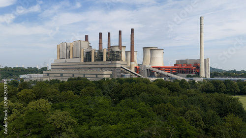 Grevenbroich, Germany - 23 June 2026: Aerial view of the RWE Power AG Kraftwerk Neurath power station with large cooling towers and chimneys rising above the surrounding forest.