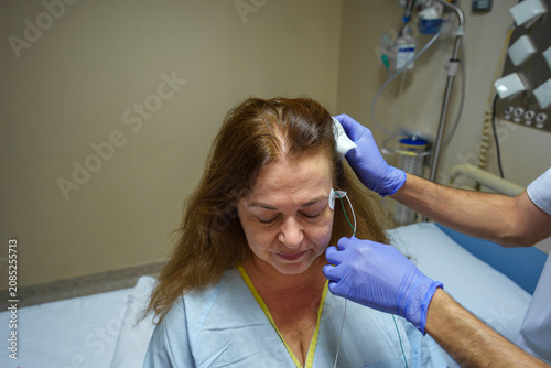 Medical professional applying electrodes on a patient's head for sleep study, diagnosing neurological conditions