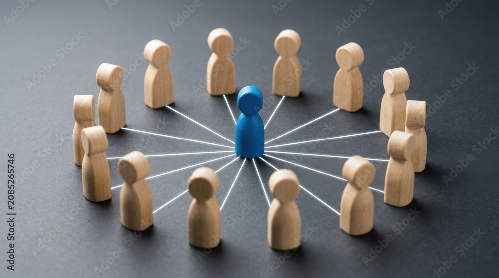 Obraz premium Blue wooden figure standing in a circle of connected wooden people on dark background