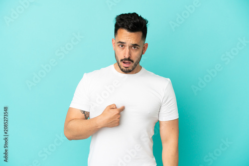 Фотография Young caucasian man isolated on blue background pointing to oneself