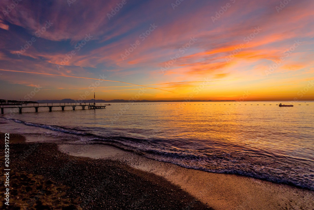 Fototapeta premium Colorful sunset over Mediterranean Sea beach with pier on the Turkish Riviera
