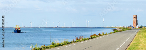 Panoramic view of the Eastern Scheldt estuary near Plompe Toren (Zeeland, Netherlands) with mussel fishing vessel, storm surge barrier and wind turbines
