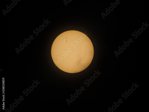 Sun disk with visible sunspots, showcasing solar activity and stellar surface during daytime observation