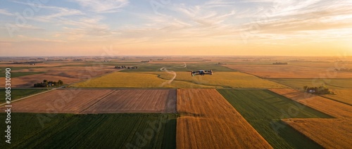 Drone surveys regenerative farmland showing technology and harvest during golden hour.