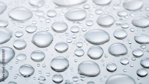 Macro view of numerous shimmering water droplets glistening on a reflective surface showcasing the pure liquid s spherical shapes and textures creating a visually appealing abstract pattern for