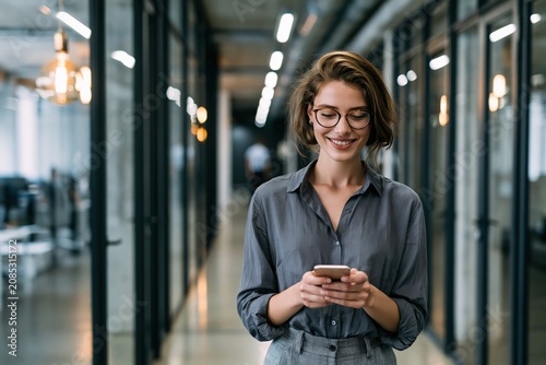 Smiling Businesswoman Reading Text Message On Phone