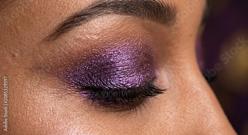 Close-up of an eye decorated with shimmery purple eyeshadow