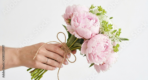 Bouquet of Fresh Pink Peonies Held by a Person Against White Background