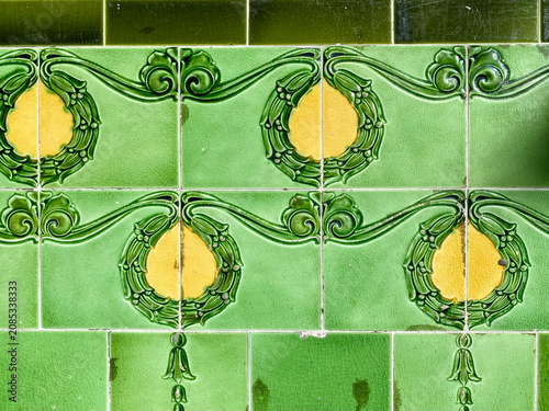Detail of decorative, bright green and yellow, Victorian tiles on the exterior wall of a bar in The Rocks, Sydney.