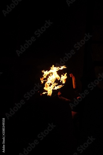 Canvastavla Fire Show performer spinning burning poi at night on dark background