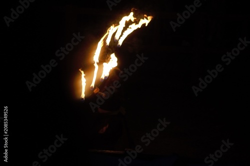 Photos Fire Show performer spinning burning poi at night on dark background
