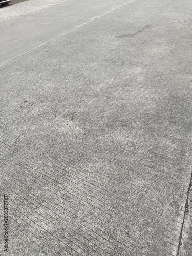 Fotografie High angle view of textured grey concrete pavement with brushed linear lines and