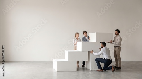 Business Team Building a Staircase with Blocks for Success